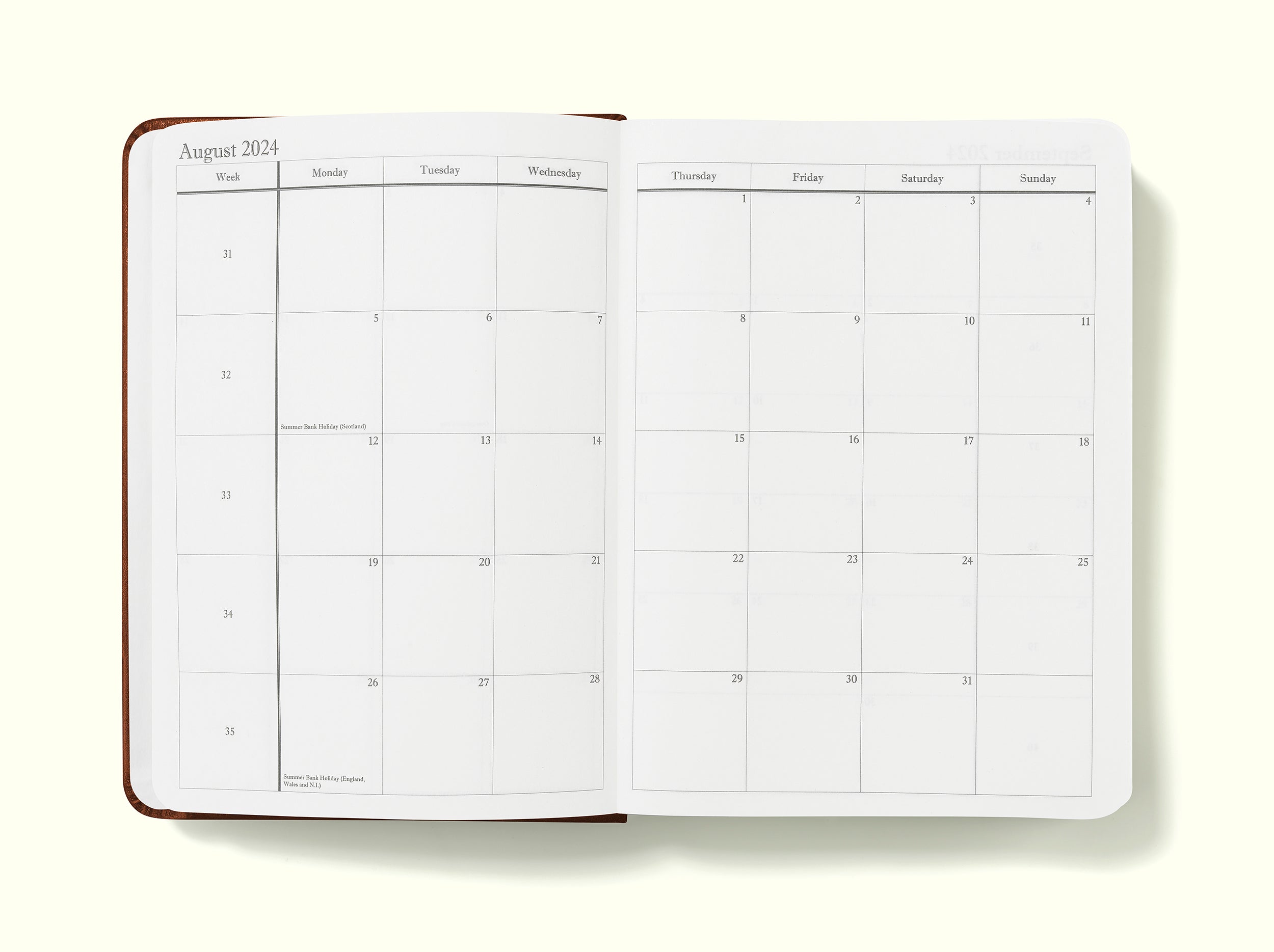 monthly planning pages of black 2024 daily journal in a6 sitting on blank background