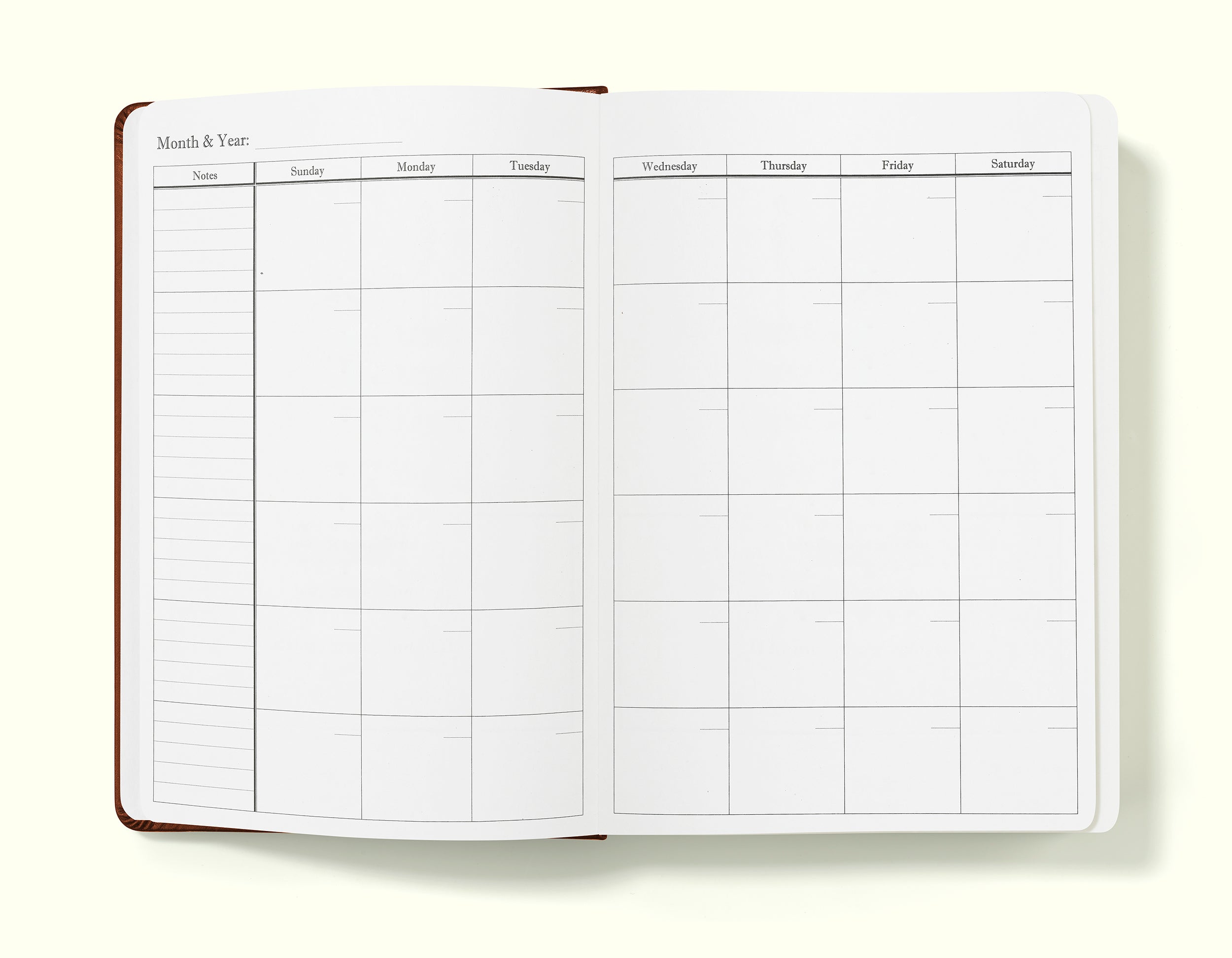 monthly planning pages of brown 2024 daily journal in a5 sitting on blank background