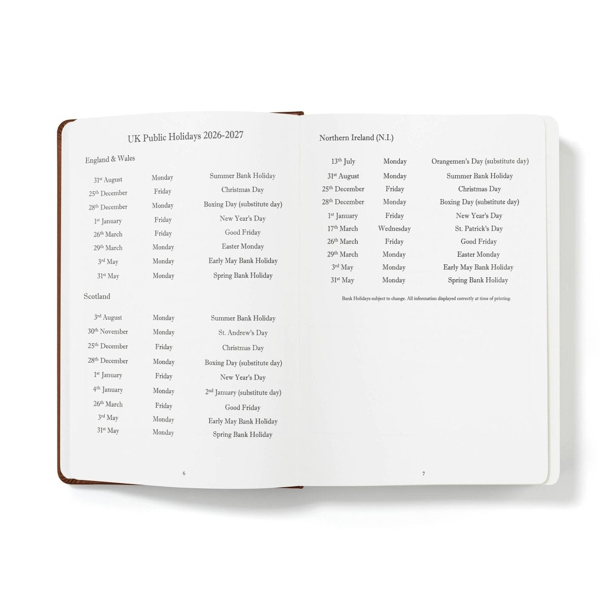 Open journal pages listing UK public holidays and dates, white paper with dark brown page border