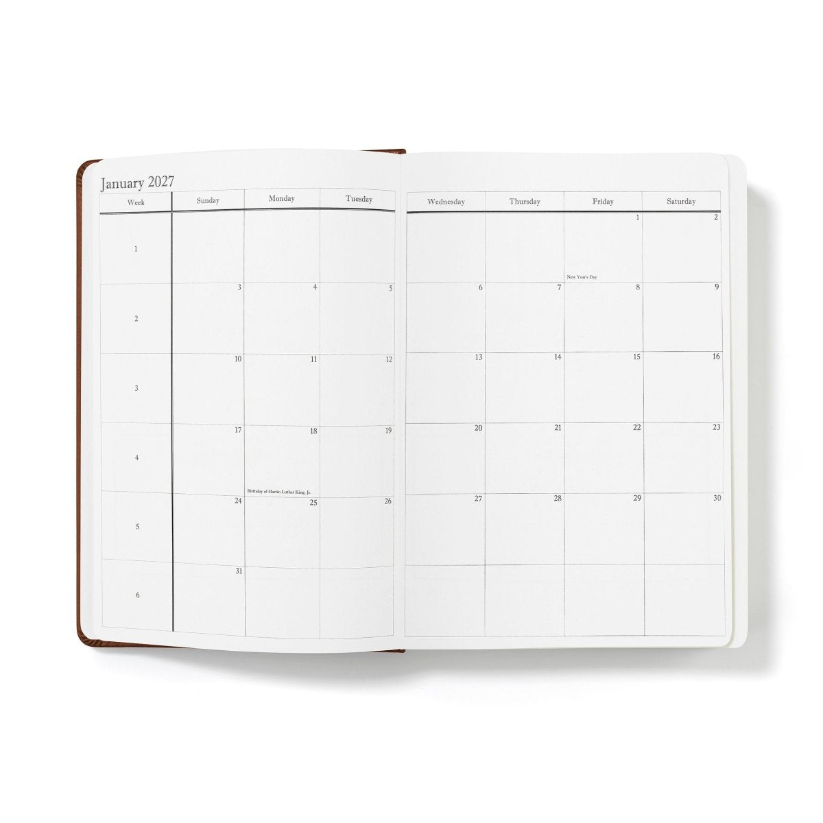Mid-year planner open to January 2027 monthly calendar grid, white pages with brown spine
