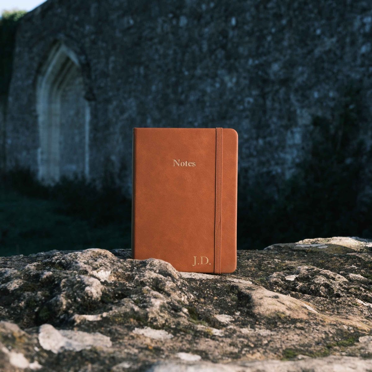 Tan executive notebook with embossed 'Notes' and 'J.D' on the bottom