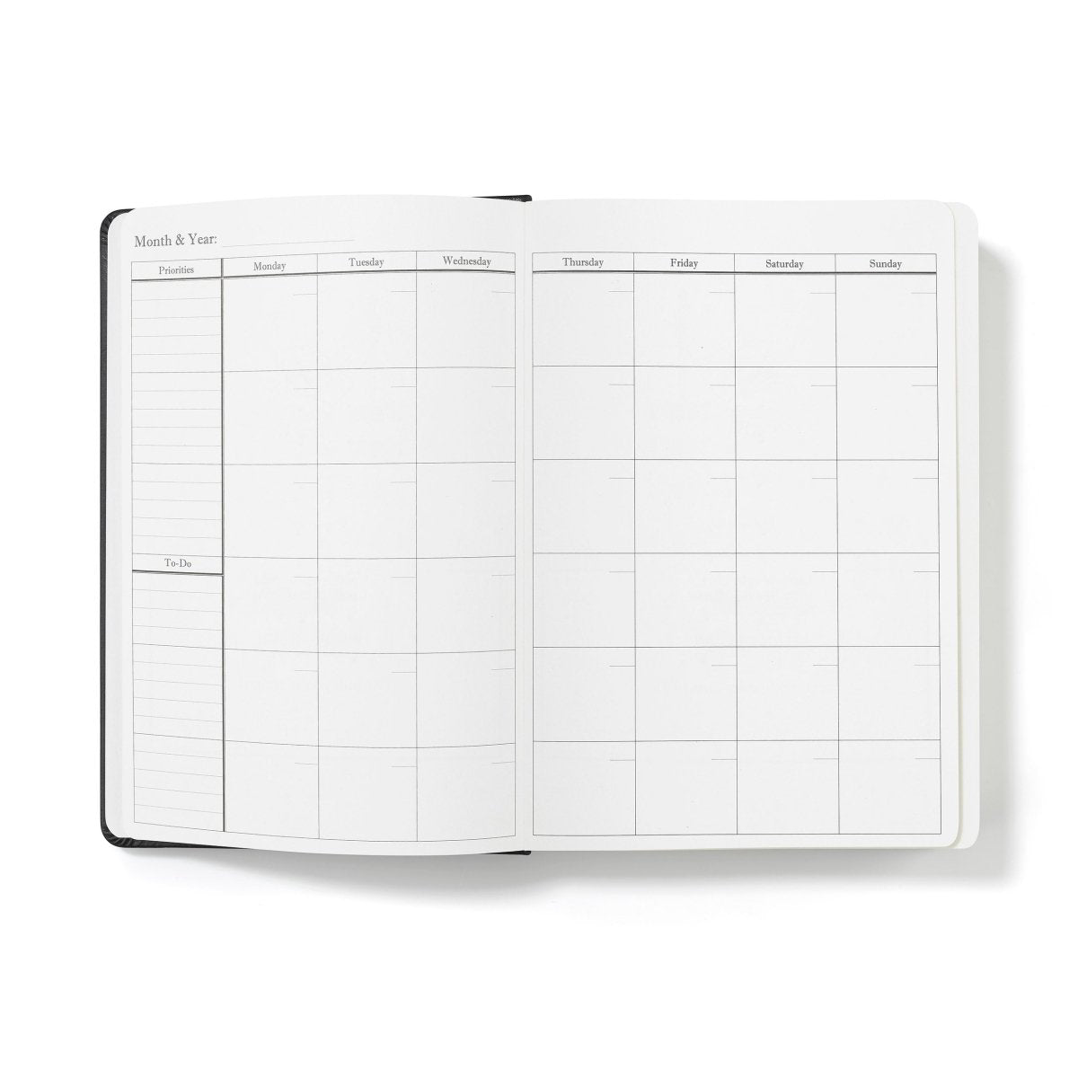 Open weekly productivity planner journal with monthly calendar grid layout and labeled days
