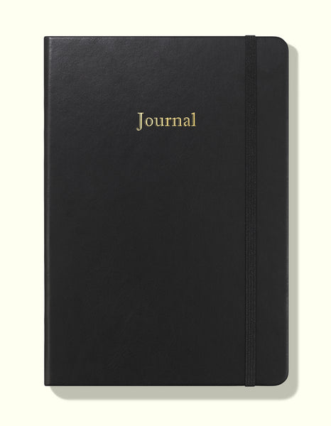 front cover of black undated daily journal in a5 sitting on blank background