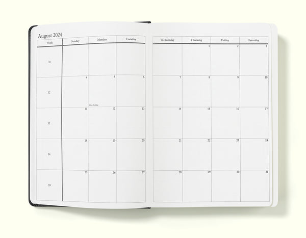 monthly planning pages of black 2024 daily journal in a5 sitting on blank background