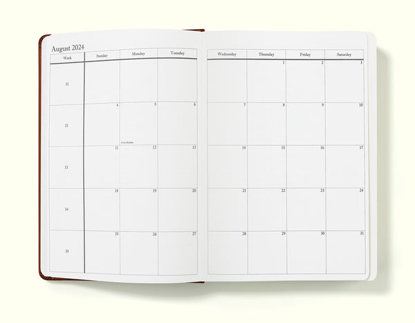 monthly planning pages of brown 2024 daily journal in a6 sitting on blank background