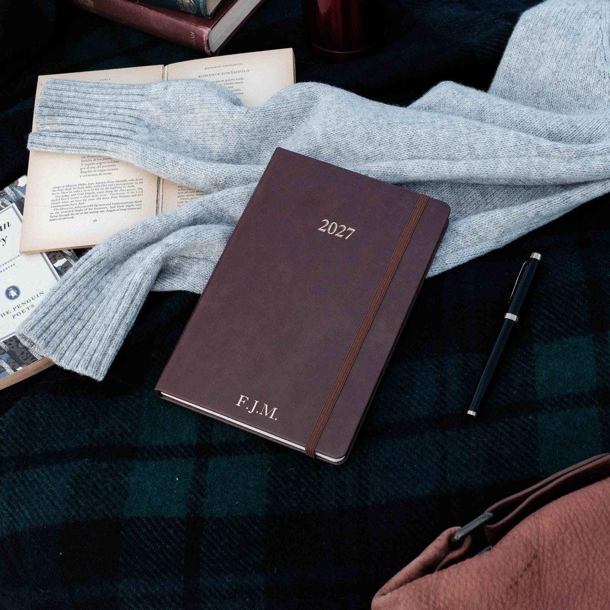 Burgundy weekly journal cover with 2027 text and F.J.M. initials