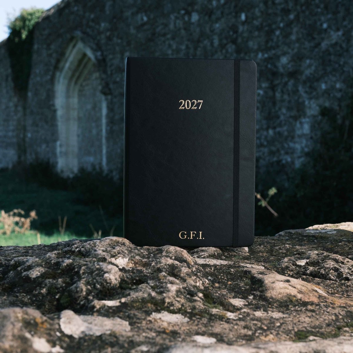 Black 2027 weekly journal with “G.F.I.” initials on the cover